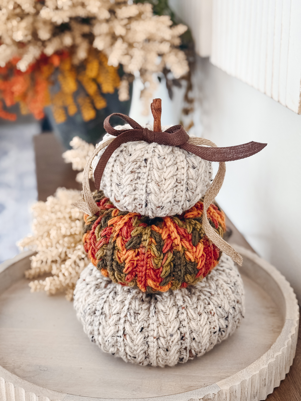 Wheat Stitch Crochet Pumpkins in oatmeal and autumn speckle stacked with a brown bow