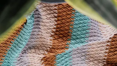 Close up of the alpine stitch texture across tan, gray and blue stripes