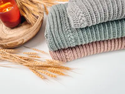 Folded child size Autumn Wheat Flat Sweaters in sage and blush