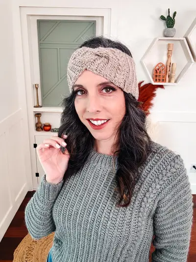 Smiling woman wearing an oatmeal Autumn Wheat Ear Warmer and a sage sweater