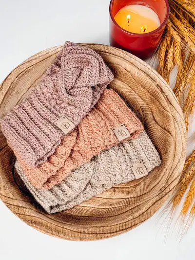 Autumn Wheat Ear Warmers in blush, peach and oatmeal stacked in a wooden bowl