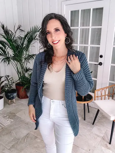 Smiling woman in the denim blue Autumn Wheat Flat Cardigan with white jeans