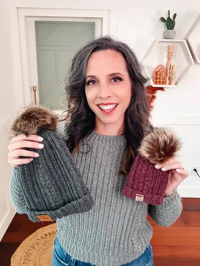 Woman holding two Autumn Wheat Flat Crochet Hats in charcoal and plum