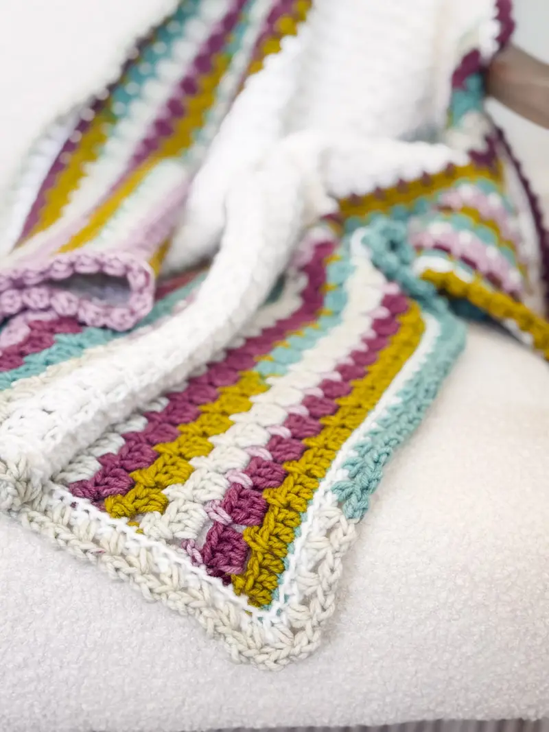 Block Stitch Crochet Blanket with stripes in mustard, purple, teal and cream on a white border