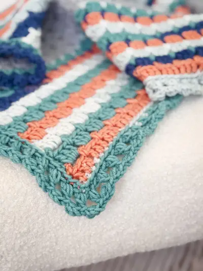 Close up of the Block Stitch Crochet Blanket border in teal, coral and navy