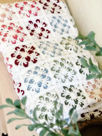 Close up of Blossom Granny Squares in cream with red, green and blue petals