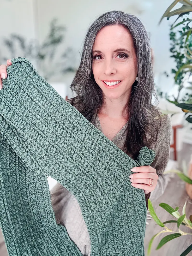 Woman holding up the sage green Braided Wheat Easy Summer Top