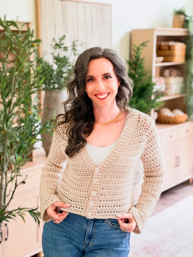 Woman wearing the cream Breeze V Neck Crochet Cardigan with jeans