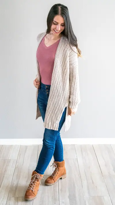 Woman in the long cream Campside Crochet Cardigan with jeans and brown boots