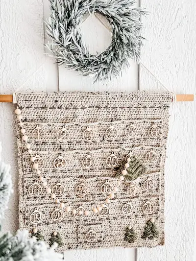 Close up of the Christmas Wall Advent Calendar pockets with a felt tree and bead garland