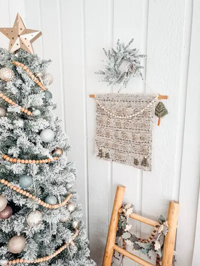 Christmas Wall Advent Calendar hanging on a white wall beside a frosted Christmas tree