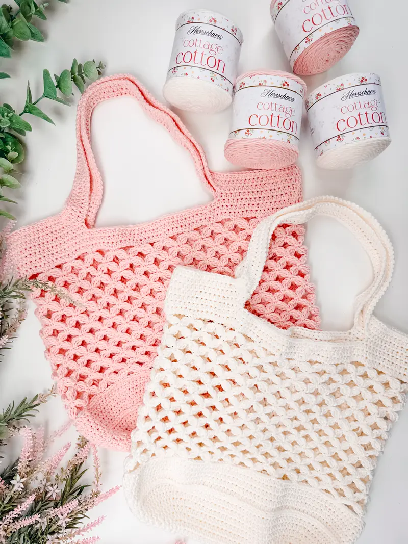 Circle Leaf Crochet Market Bags in pink and cream with skeins of cotton yarn