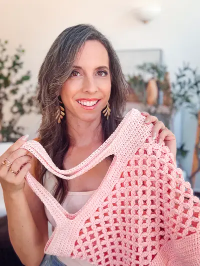 Woman holding the pink Circle Leaf Crochet Market Bag by its straps