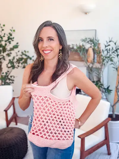 Woman carrying the pink mesh Circle Leaf Crochet Market Bag on her shoulder