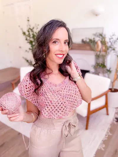 Woman in a pink Circle Leaf Lace Crochet Summer Top holding a skein of yarn