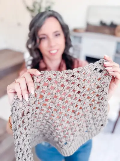 Woman holding up the taupe Circle Leaf V Neck Cardigan to show the lace