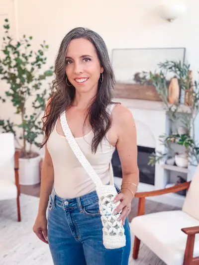 Woman wearing the white Circle Leaf Water Bottle Holder as a crossbody