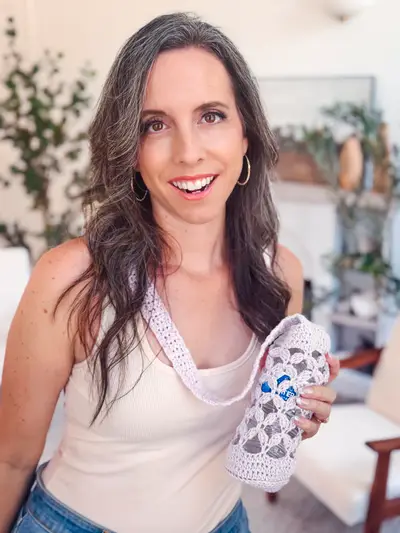 Woman holding the lilac Circle Leaf Water Bottle Holder by its strap