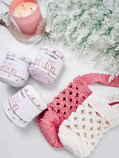 Pink and cream Circle Leaf Water Bottle Holders with skeins of cotton yarn