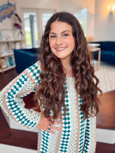 Smiling girl wearing a Classic Granny Dress in teal, white and black granny stripes