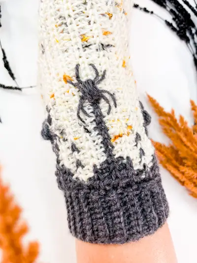 Close up of a crocheted spider and web on the Creepy Crawly Spider Crochet Socks