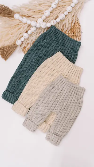 Three pairs of Cutest Baby Cuffed Pants in green, cream and gray with a bead garland