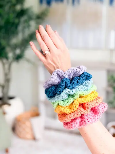 Wrist stacked with rainbow Double Bloom Scrunchies