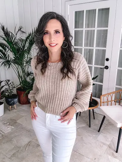 Woman wearing the oatmeal Dove Pullover with white jeans