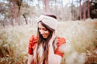 Woman wearing an oatmeal Easy Crochet Ear Warmer in a field