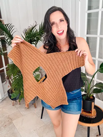 Woman holding up a rust Easy Cuff to Cuff Child Crochet Sweater