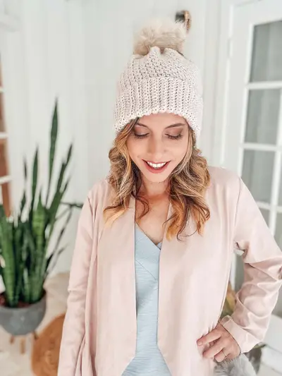 Woman wearing a cream Extend That Mellow Texture Hat with a pom pom
