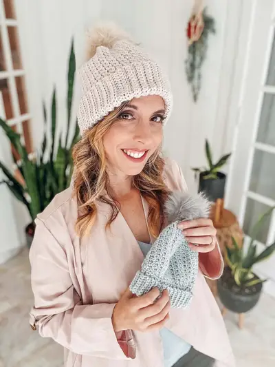 Smiling woman in a cream Extend That Mellow Texture Hat holding a blue one