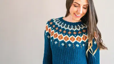 Close up of the Fawning Over You Crochet Sweater colorwork yoke in teal, rust and cream