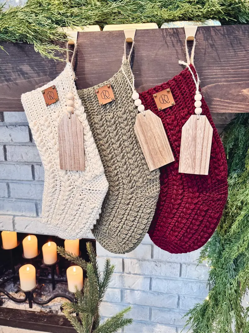 Festive Wheat Crochet Stockings in cream, sage and burgundy hanging from a mantel with wood tags