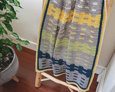 Close up of the Garden Fences Crochet Blanket's gray, yellow and navy stripes