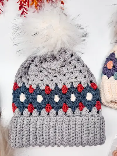Gray Gemstone Hues Crochet Beanie with a navy and red diamond band and a white pom pom