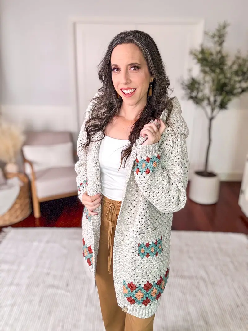 Woman wearing the cream Gemstone Hues Crochet Cardigan with colorful diamond trim and a hood