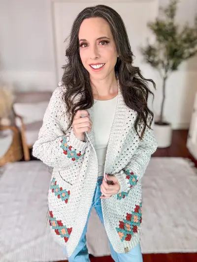 Smiling woman in the cream Gemstone Hues Crochet Cardigan with diamond trimmed pockets