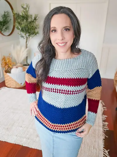 Woman in the Gingersnap Pullover in light blue, red, navy and rust stripes