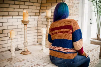 Back view of a model in the rust and navy striped Gingersnap Pullover