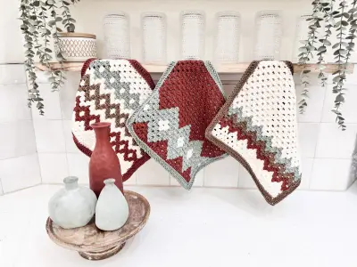 Gemstone Hues Crochet Blanket squares in rust, cream and gray laid out with decor