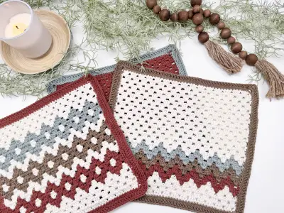 Folded Gemstone Hues Crochet Blanket panels with a candle and bead garland