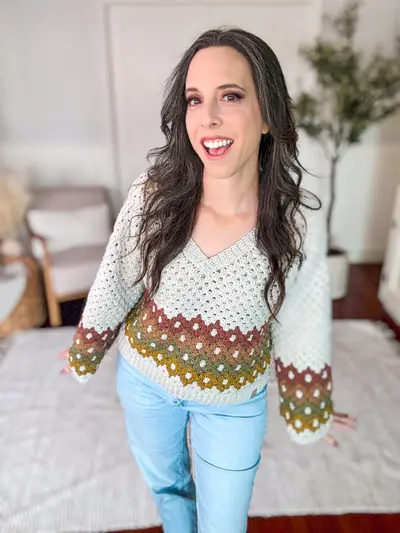 Smiling woman wearing the cream and gold Shades of Diamonds Crochet Pullover