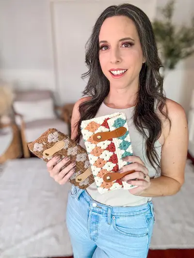 Woman holding two Harvest Hues Crochet Clutches in rust and teal