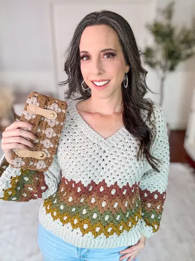 Woman in a Harvest Hues sweater holding a Harvest Hues Crochet Clutch