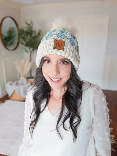 Woman wearing a cream Harvest Hues Crochet Beanie with teal accents