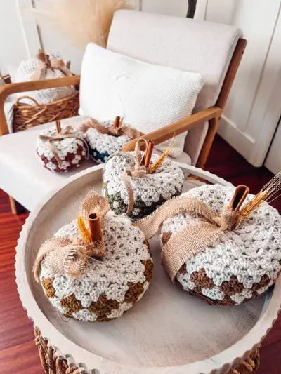 Harvest Hues Crochet Pumpkins arranged on a footed tray by an armchair