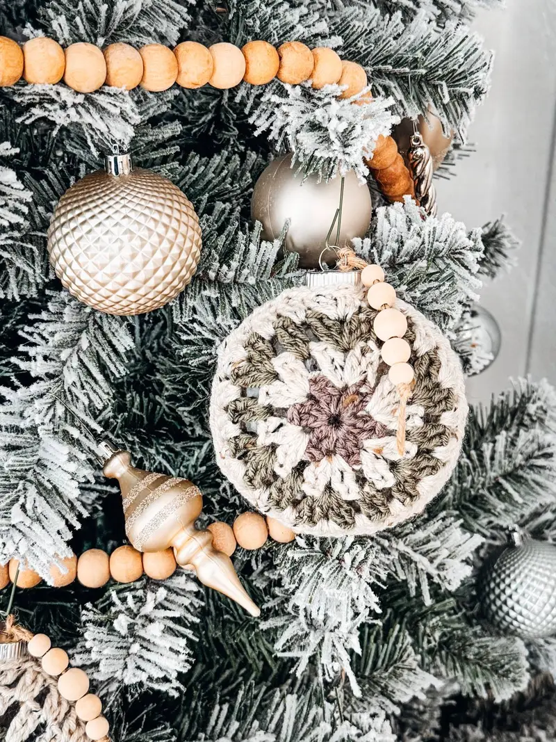 Hexagon Granny Bauble Ornament in cream and taupe hanging on a flocked Christmas tree