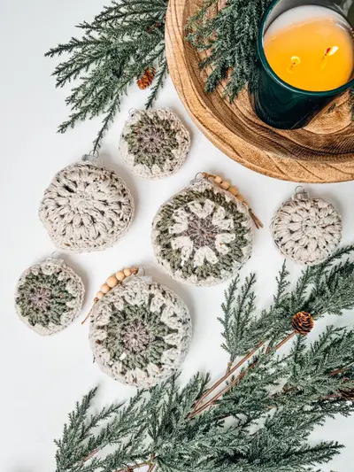 Hexagon Granny Bauble Ornaments in cream and sage with pine branches and a candle