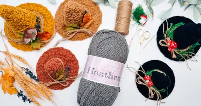 Flat lay of Witch Hat Trio pieces in mustard, rust and black with yarn